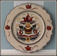 an ornately decorated plate hangs on the wall