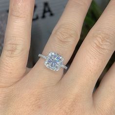 a woman's hand with a diamond ring on top of her finger and an engagement band