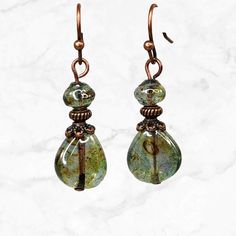 Lovely teardrop woodland green Czech glass teardrop and shell shaped beads. These minimalist earrings have a beautiful luster with a light golden wash. Exceptional beads. Everyday jewelry, short earrings. Copper finish beads, bead caps.  Can be worn casually or for dress up. Really beautiful beads with just the right amount of shimmer. Longer version: https://www.etsy.com/listing/1349678467/green-woodland-long-earrings-green Also available in PURPLE here: https://www.etsy.com/listing/1381407117/purple-teardrop-earrings-boho-earrings Artisan glass beads produced in small quantities in Czech Republic  Hypoallergenic ear wires (nickel and lead free). Choose ear wire style at checkout. A gift for you or someone special, earrings are carded and in an organza bag. Link back to my shop: https://w Layer Earrings, Woodland Earrings, Earthy Jewelry, Earthy Green, Reno Nv, Funky Jewelry, Teardrop Beads, Nature Inspired Jewelry, Bohemian Earrings