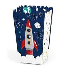 a small gift bag with a rocket ship on the front and stars around it,