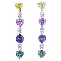 An elegant pair of Graff earrings, made of platinum, featuring diamonds and multi-colored sapphires. Each earring has three heart-shaped sapphires (yellow, pink, and green), one round sapphire (purple), and three round diamonds. The gems are set in a line one above another to create a gorgeous sparkling thread. These Graff earrings are classic and refined. With Graff being committed to upholding the highest standards of craftsmanship, they are a great investment piece, without mentioning their i Graff Earrings, Graff Jewelry, Colored Sapphires, Platinum Earrings, Round Sapphire, Jewelry Auction, Sapphire Earrings, Sapphire Stone, Precious Gemstones