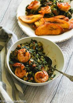 two bowls filled with shrimp and greens on top of a wooden table next to a white plate