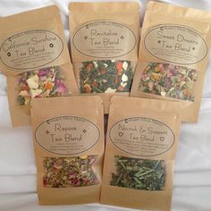 four bags of tea blends sitting on top of a bed