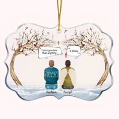 an ornament with two people sitting in the snow and one is talking to each other