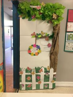 a door decorated with paper flowers and leaves in the shape of a tree is shown