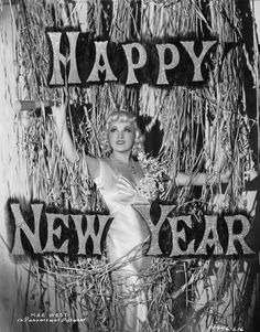 an old black and white photo of a woman in front of a happy new year sign