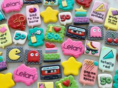 decorated cookies are arranged in the shape of children's books and toys on a table