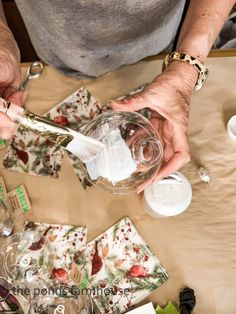 a person pouring something into a glass on top of a table covered in napkins