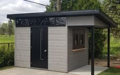 a small gray shed with a black door