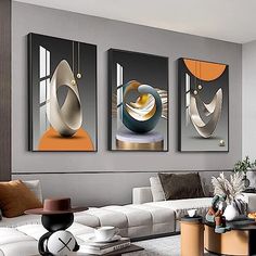 three paintings hanging on the wall in a living room with couches and coffee table