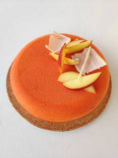 an orange cake with apple slices on top and cheese sticks sticking out of the side