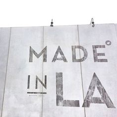 a woman standing in front of a wall that says made in la