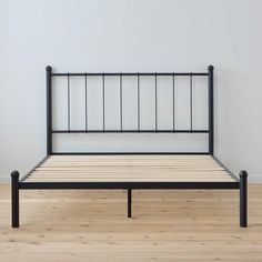 a bed frame sitting on top of a hard wood floor next to a white wall