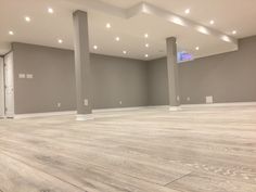 an empty room with wooden floors and gray walls