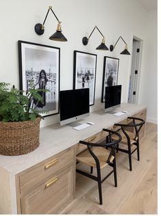 a desk with three computer monitors on it and two chairs in front of the desk