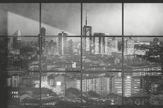 an image of a city seen through a window with the reflection of buildings in it