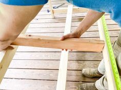 two men are measuring the length of a piece of wood