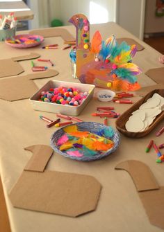 the table is set up with craft supplies and paper plates on top of cardboard boxes