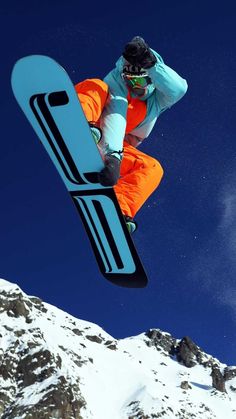 a man flying through the air while riding a snowboard on top of a mountain