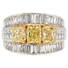 Presenting our Natural Diamond Cluster Ring, a true marvel of exquisite craftsmanship. This remarkable piece features three radiant-cut fancy yellow diamonds elegantly positioned side by side, complemented by two rows of princess-cut white diamonds and two additional mirrored rows of baguette-cut diamonds. Set in pristine 18k white gold, this unique statement piece is truly one-of-a-kind, ensuring you stand out with unparalleled style. Get this ring for you or your loved ones this holiday season Luxury Yellow Diamond Wedding Ring, Elegant Yellow Baguette Cut Diamond Ring, Luxury Yellow Baguette Cut Ring, Yellow Baguette Cut Fine Jewelry Ring, Gia Certified Yellow Baguette Cut Ring, Luxury Yellow Asscher Cut Ring, Yellow Baguette Cut Diamond Ring With Vvs Clarity, Luxury Yellow Diamond Anniversary Ring, Yellow Diamond Ring With Emerald Cut