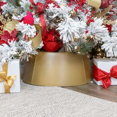 two christmas presents sitting on top of a table next to a tree with red and white decorations