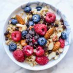 a bowl filled with granola, berries and nuts