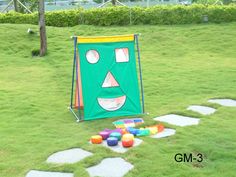 an outdoor play area with colorful balls and a green face