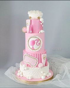 a three tiered cake with pink and white decorations