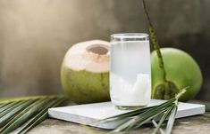 a glass of water next to some coconuts