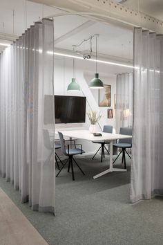 an office with white curtains and grey chairs