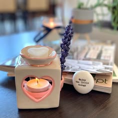 a candle holder sitting on top of a wooden table next to a plate with a heart