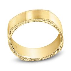 a gold wedding ring with intricate engraving on the sides and an engraved design in the middle