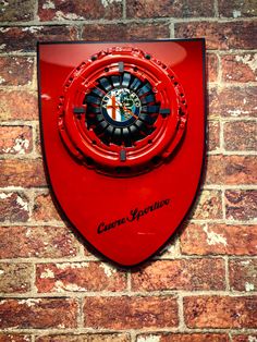 a red sign mounted to the side of a brick wall