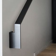 a door handle on the side of a wall in a room with wood floors and white walls