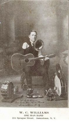 an old black and white photo of a man holding a guitar