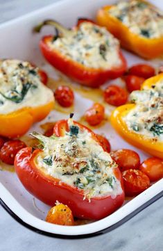 stuffed peppers with cheese and tomatoes in a casserole dish, ready to be eaten