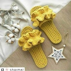 two crocheted slippers and a star ornament are laying on a bed