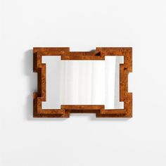 a mirror that is on the wall next to a white wall with a wooden frame