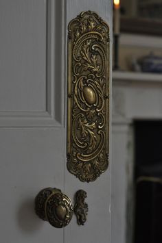 an ornate door handle on a white door