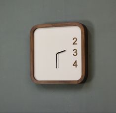 a square clock mounted to the side of a wall with numbers on each side and one minute left