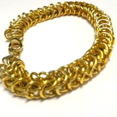 This gold chainmaille bracelet created by Jewelry By Luet and Co is made of: Gold plated jump rings and gold plated lobster claw clasp and findings.  This bracelet measures 7 ½ inches in length.  This makes an excellet charm bracelet.To view more wire wrapped bracelets:  http://www.etsy.com/shop/cdjali?section_id=7312193WE OFFER FREE STANDARD SHIPPING WITHIN THE UNITED STATES!All of our jewelry is unique and custom designed. We would love to assist you with any custom orders or needs for special Gold Metal Bracelet With Lobster Clasp, Handmade Gold Charm Bracelet For Jewelry Making, Gold Handmade Chain Link Bracelet, Handmade Gold Link Bracelets, Handmade Gold Brass Chain Bracelet, Chunky Jewellery, Wrapped Bracelets, Jewelry Chunky, Artisan Fashion