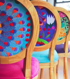 three chairs with brightly colored cushions on them