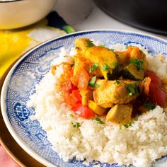 a blue and white plate topped with rice and chicken