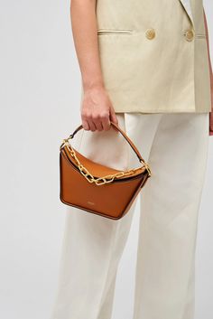 [vc_row][vc_column width=”1/3″][vc_column_text text_larger=”no”] Oroton Women’s Fable Small Day Bag   Oroton Fable Small Day Bag The Oroton Fable Small Day Bag, crafted from smooth leather and lined with 100% cotton twill, it exudes sophistication. The brass colour hardware and signature foil embossed logo add an elegant touch. This bag features one compartment with an internal card sleeve pocket for easy organisation. Designed with a removable top handle, a ch Chic Cognac Evening Bag, Chic Evening Bucket Bag In Cognac, Chic Cognac Bags With Gold-tone Hardware, Chic Cognac Rectangular Shoulder Bag, Chic Rectangular Cognac Shoulder Bag, Chic Cognac Rectangular Bag, Chic Rectangular Cognac Bag, Oroton Bag, Design Your Own Shoes