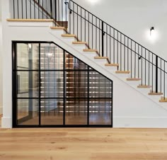 an empty room with stairs and glass doors