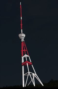 a red and white tower with a clock on it's side in the dark