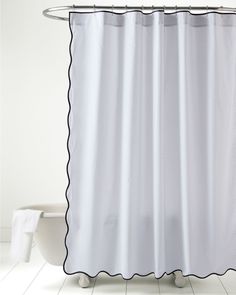 a white shower curtain with black scalloped edges