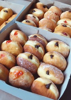 two boxes filled with donuts covered in frosting