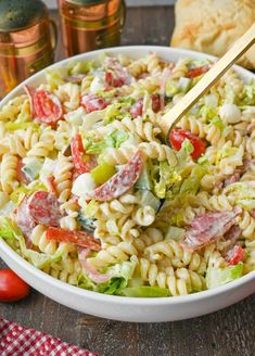 a bowl filled with pasta salad next to bread