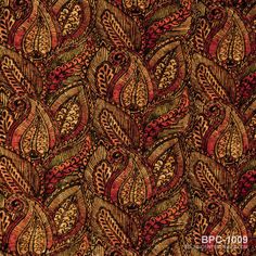 an image of a red and brown paisley print fabric with leaves on the back ground